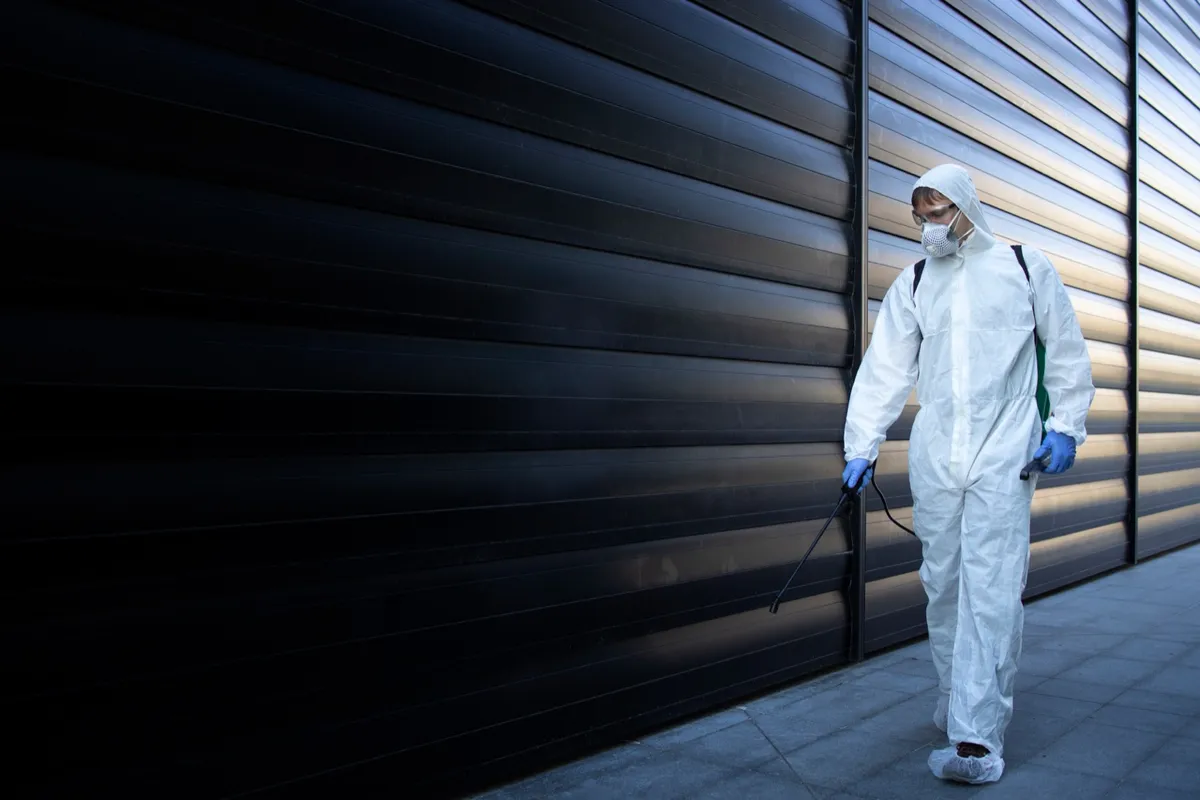 Technician walking an exterior wall during a pest inspection